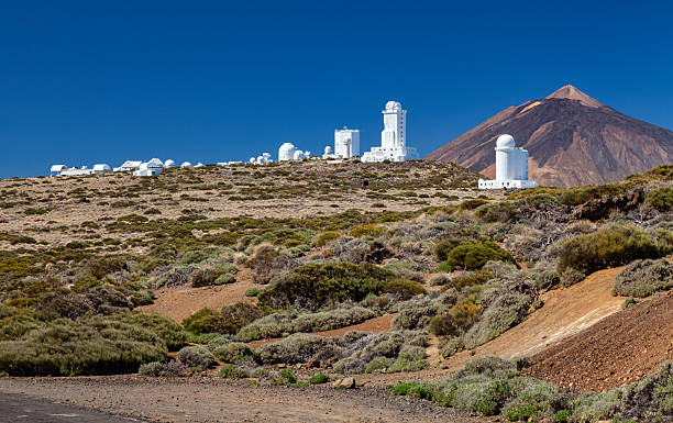 Teide Observatory (Observatorio del Teide) and Mount Teide in Background, Tenerife, Canary Islands, Spain. White domes of Teide Observatory under clear blue sky with volcanic Mount Teide towering behind on Tenerife. observatory tenerife canary islands el teide national park stock pictures, royalty-free photos & images