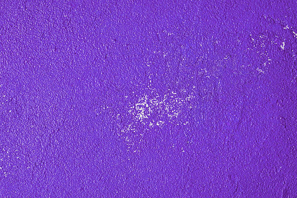 Close-up of an abstract red surface with sweeping textures and small, scattered holes. The image captures the rich, layered texture and varying shades of red, creating a visually dynamic composition.