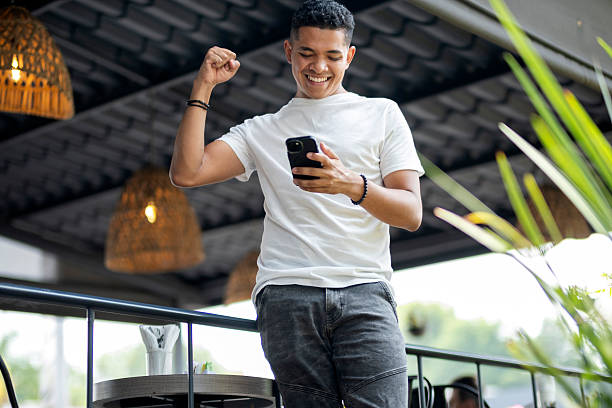 istock happy young man interacting with his cell phone 2219353969