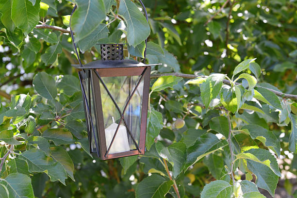 Closeup of a generic, mass produced candle lantern in a backyard garden.