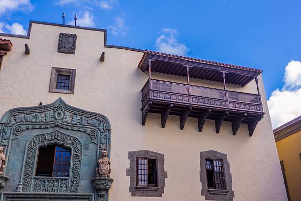 Ornate balcony on Casa de Colon facade under a blue sky in Las Palmas