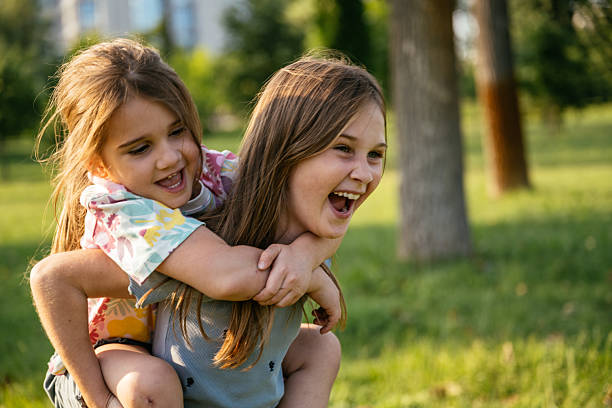 istock Nine year old sister carrying her sibling on piggyback 2219358616