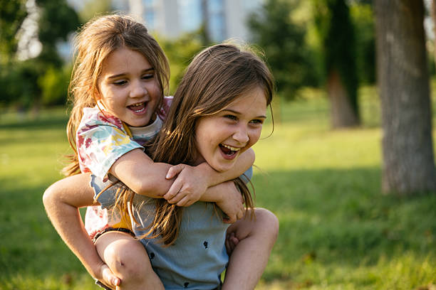 istock Nine year old sister carrying her sibling on piggyback 2219358637