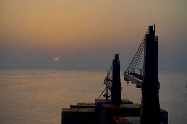 Aerial drone view of a container ship anchored in a harbor.