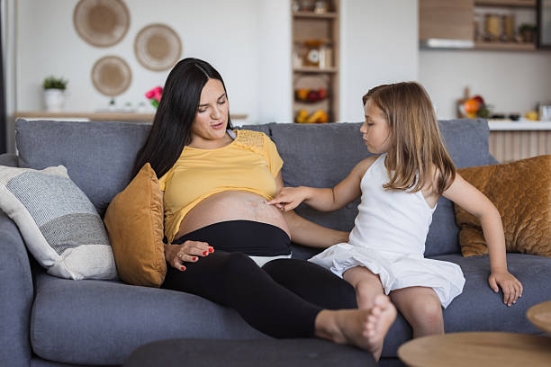 istock Child touching her mother's pregnant belly 2219361175