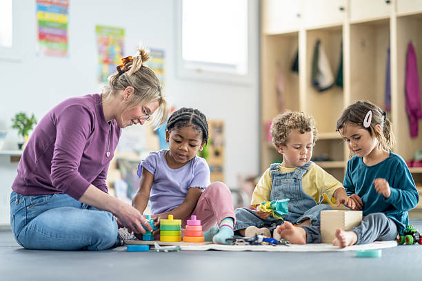 istock Teacher Engaging With Children in Creative Learning Activities at Daycare 2219363072