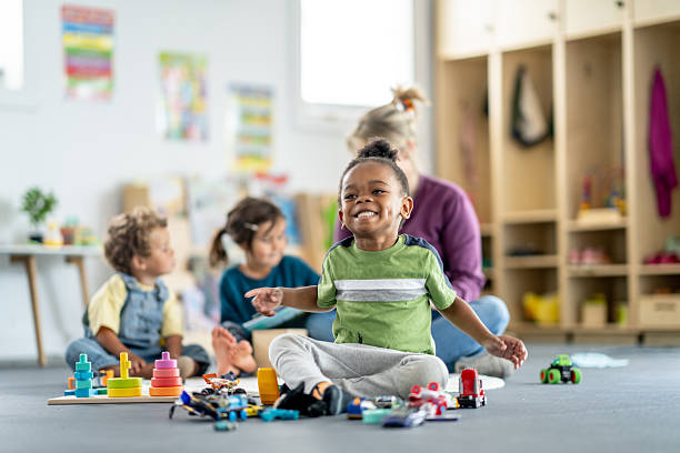 istock Smiling Children Playing in a Bright and Colorful Daycare Classroom Setting 2219363455