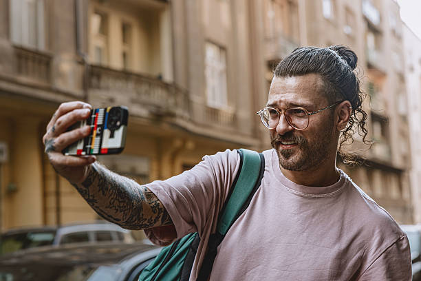 istock rendy young man laughing while talking on smartphone outdoors in urban setting 2219363580