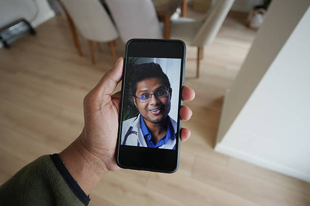 istock Person Holding Smartphone Displaying a doctor Smiling Face 2219363677