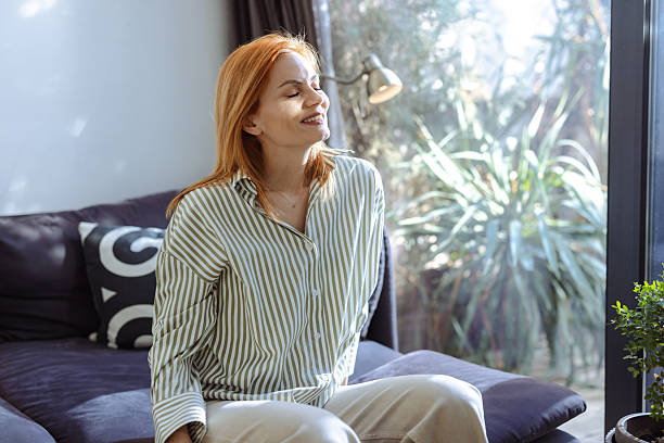 istock Woman enjoying sunshine indoors with a serene and relaxed expression 2219366449
