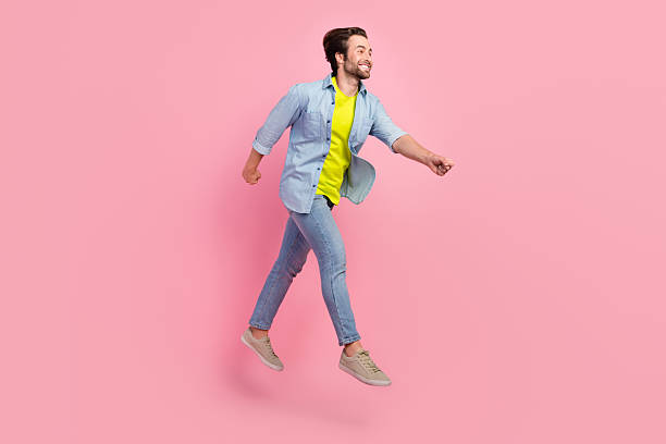 istock Full length profile side photo of young guy jump runner hurry look empty space isolated over pink color background 2219366584