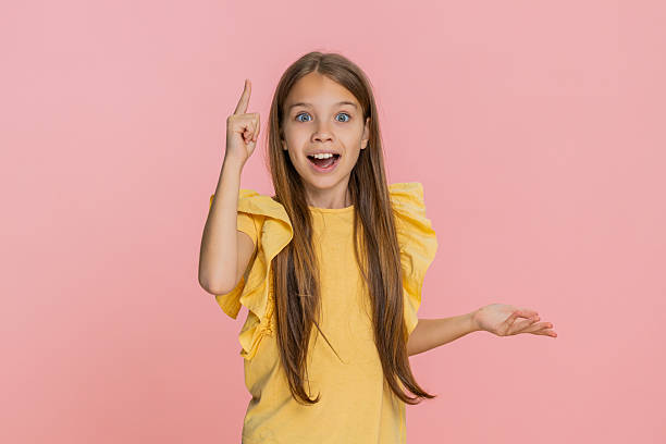 istock Child girl kid thinking deeply smiling raising finger up after finding genius idea eureka moment 2219370297