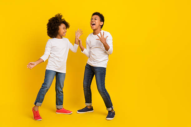 istock Photo of attractive impressed schoolkids dressed white shirts screaming empty space isolated yellow color background 2219371663