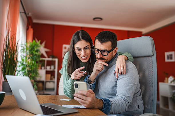 istock A couple looking at mobile phone together while working from home 2219372747