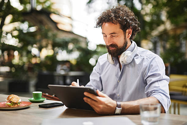 istock Freelancer working on tablet at outdoor cafe during lunch break 2219373583