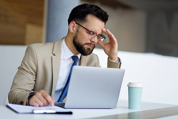 istock Overworked executive suffering head pain during laptop work, displaying workplace stress in modern corporate environment 2219373668