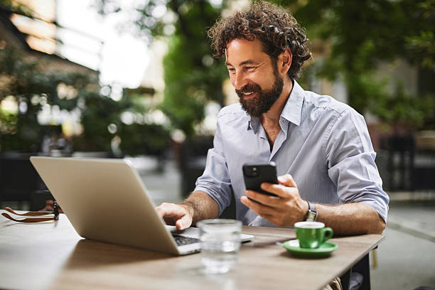 istock Freelancer working remotely from a cafe using laptop and smartphone 2219373760