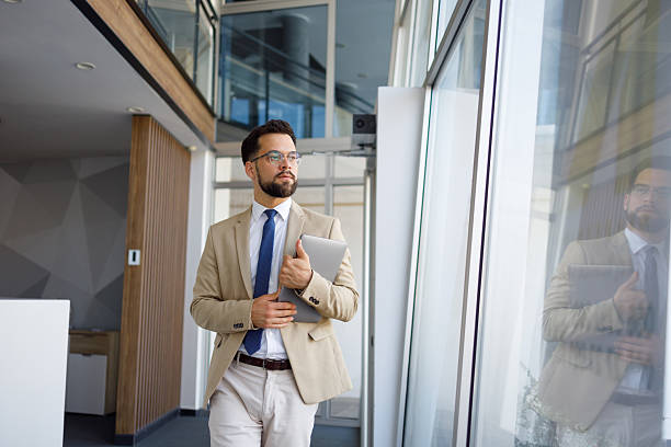 istock Professional executive striding across sleek workspace, laptop in hand, contemplating strategic vision with focused composure 2219373993
