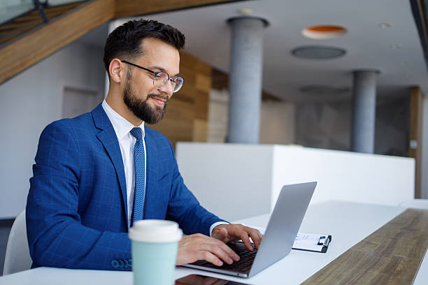 istock Professional male working diligently on laptop, centered within contemporary minimalist workspace 2219376336