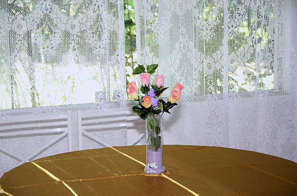 Beautiful shape of pumpkins on dinning table arrangement. Star like pumpkin and vase of colorful flowers (yellow, orange, red, green, purple, black). It is a round table with four chairs arranged for a special occasion. Unique design. Located in Corona, California.
