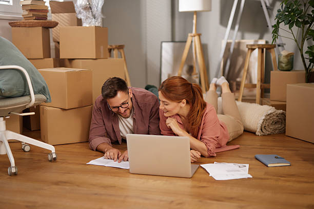 istock Happy couple lying on floor planning new home using laptop 2219379448