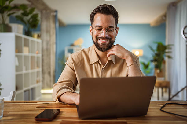 istock adult satisfied man work or use laptop computer in modern living room 2219379640