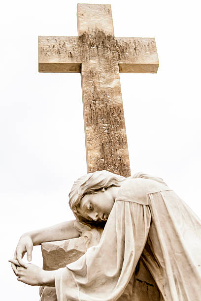 Evocative stone angel statue in repose, symbolizing mourning and remembrance, weathered by time at Donskoy Monastery cemetery. October 23, 2018. Moscow, Russia