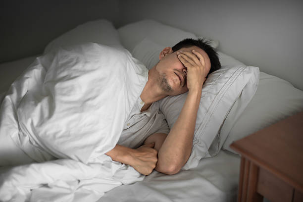istock Young man waking up feeling tired suffering from insomnia bad sleep. 2219389458