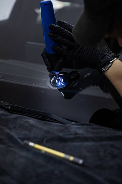 istock Windshield Crack Repair with Drill. Drilling a crack in the windshield prepares the impact area for flawless repair. Resin flows deeper and bonds better after a clean drill point. 2219389496