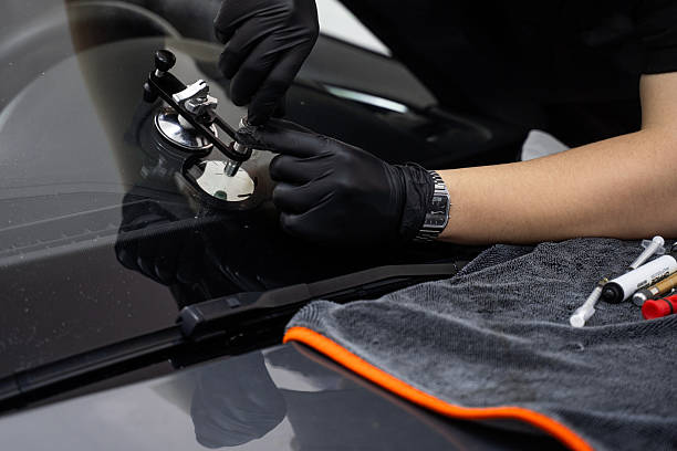 istock Handheld windshield crack repair for stable resin injection. Repair bridge stabilizes injector while resin is pressed into chip. Suction mount holds steady pressure during curing. 2219389839