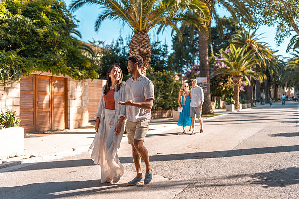 istock Diverse Couples Strolling Coastal Palm Promenade 2219392638