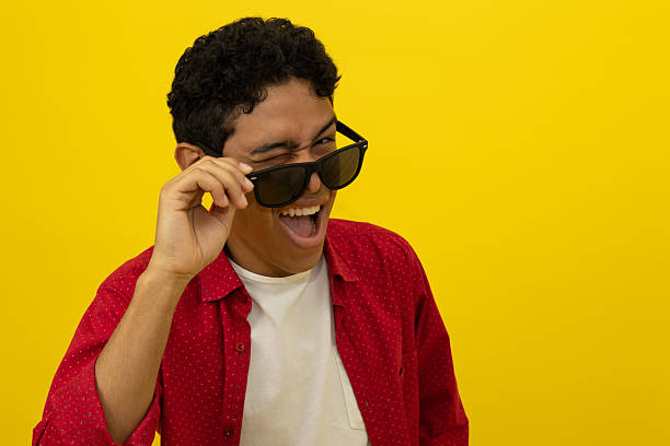 istock Close up of a young Latino man taking off his glasses while winking 2219395443