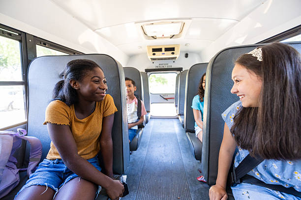Diverse children sitting on the school bus seats
