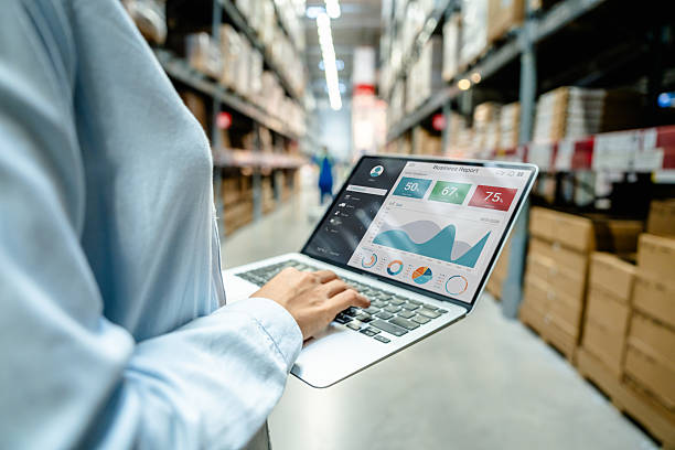 istock Employee using a laptop with business analytics dashboard in a modern warehouse, showing real-time data monitoring and smart supply chain management for logistics and inventory control. 2219397399