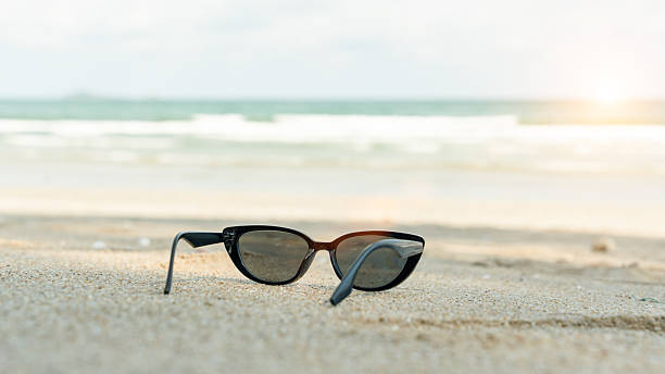 istock Sunglasses on sandy beach in summer, sunny day 2219402391