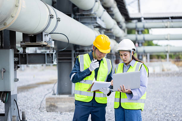 istock Engineer working at power substation high voltage infrastructure inspection and check with safety helmet and vest in industrial environment 2219405348