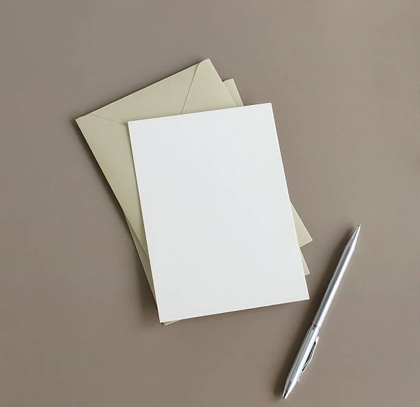 istock Blank paper card mockup . envelopes, pen top view on brown background . Copy space. 2219414009