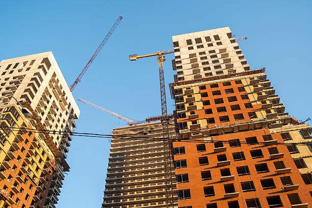 istock Vertical view of three partially constructed skyscrapers with visible tower cranes. The image captures the process of high-rise construction, showcasing the urban architectural development. 2219415547