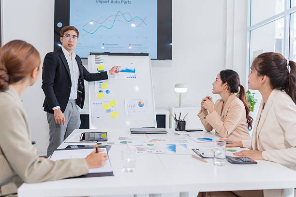 istock Group of Asian business people present their work on a table with graph paper. 2219416605