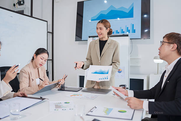 istock Group of Asian business people present their work on a table with graph paper. 2219417207