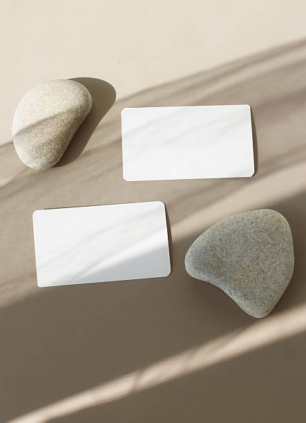 istock Cards mockup template, empty blank paper, business cards with stones and sunlight shadow top view on brown background. 2219417543