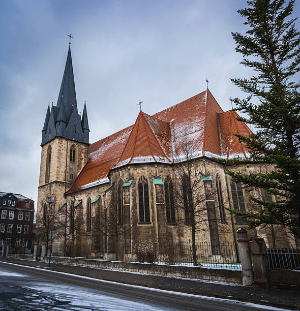 Church with a tall steeple under a cloudy sky in a Snowy Town