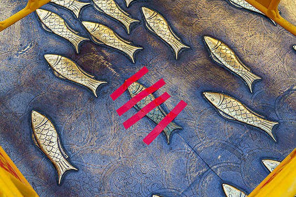 A copper fish installation designed for a commercial pedestrian street is temporarily secured with pink tape during repair or renovation work