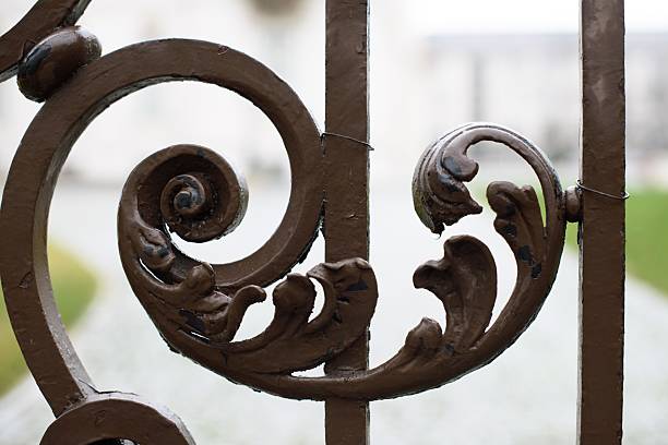 Silhouetted ancient open cast iron gate, low angle view. Peso da Régua, Portugal . Antiquities.