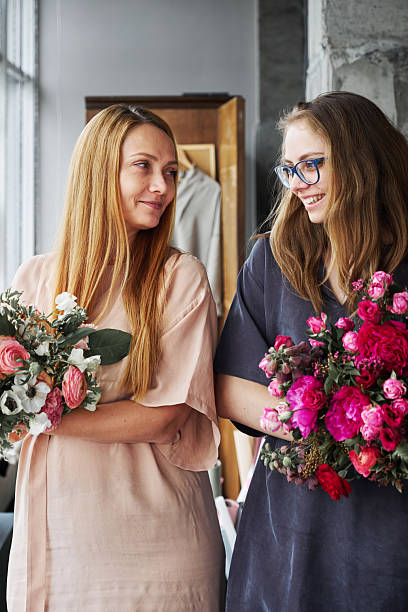 istock Mother and daughter with fresh flower bouquets 2219424079