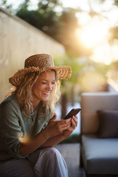 istock Happy woman text messaging on cell phone on a patio. 2219424669