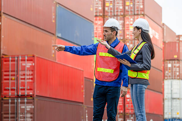 istock Engineer and foreman worker team in hardhat and safety vest checking containers box from cargo, Engineers team with clipboard managing cargo operations, Teamwork concepts 2219426582