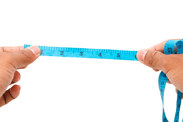 istock Hands holding a blue measuring tape, demonstrating precision measurement in garment creation 2219428343