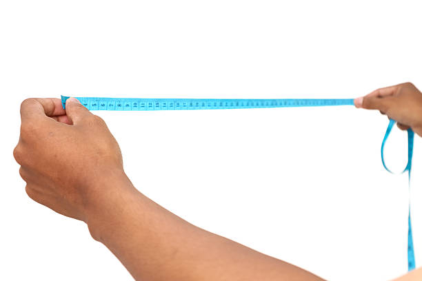 Hands holding a blue measuring tape in a bright studio setting.