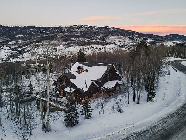 istock Cozy cabin in a snowy winter landscape at sunset. 2219430081